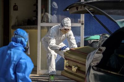 Un empleado de una casa mortuoria mueve el ataúd de una víctima de COVID-19 en un crematorio en el barrio de Xoximilco, en la Ciudad de México, el 5 de mayo de 2020.