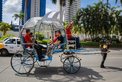 Un propietario de carreta de las llamadas "Las Calandrias", que brinda servicio al turismo en el puerto de Acapulco (México), arrastra este martes el vehículo para mostrar que con este acto no se maltrata al caballo que es el complemento de esta atracción turística en el estado de Guerrero (México).
