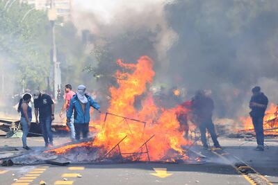 Manifestantes queman objetos durante una protesta contra el incremento del precio en los billetes del metro, este sábado en Santiago (Chile).