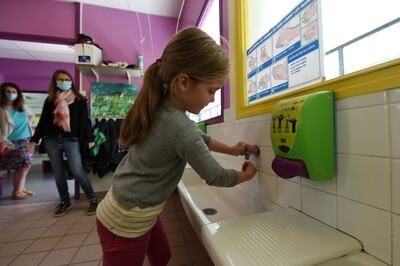 Una niña francesa se lava las manos en la escuela. Europa debate si es conveniente reabrir los centros educativos, mientras científicos estudian el papel de los menores en la transmisión del covid-19.