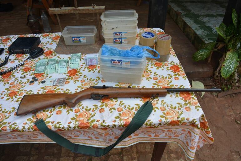 Un arma, dinero en efectivo y otros elementos incautados por los investigadores.