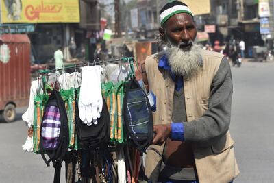 Un vendedor vende máscaras protectoras como medida de prevención contra el coronavirus COVID-19 a lo largo de una calle en Multan.