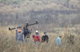 peones-y-funcionarios-de-una-empresa-privada-tratan-de-desprender-uno-de-los-postes-incendiados-presumiblemente-por-un-grupo-de-campesinos--193527000000-587498.jpg