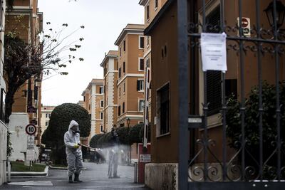 Un hombre lleva a cabo operaciones de desinfección en un barrio durante el cierre de emergencia debido al brote de coronavirus Covid-19 en Roma, Italia,