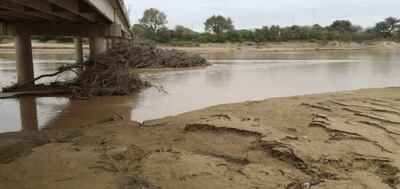 Una gran cantidad de palos atascados se puede observar por los   pilares del puente Pozo Hondo-Misión La Paz (Argentina).