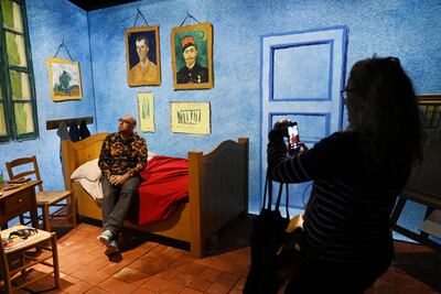 Un visitante interactúa con la recreación de la cama del pintor Vincent Van Gogh.