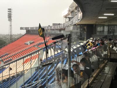 Los aficionados buscan resguardarse de la lluvia.