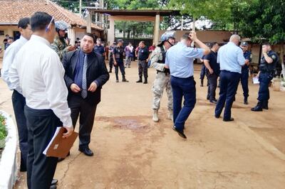 Funcionarios penitenciarios y agentes policiales se preparan para catear los pabellones, una vez controlada la gresca.