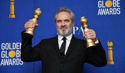 El cineasta británico Sam Mendes exhibe los dos Globos de Oro recibidos por su película dramática “1917”.