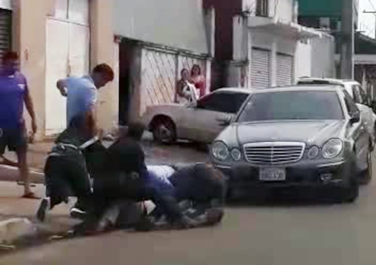 Estando en el piso, un hombre de remera celeste encaja una patada a uno de los denunciantes de esta pelea registrada en Ciudad del Este.
