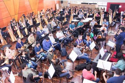 La OSN y el ensamble de arpas en pleno ensayo.