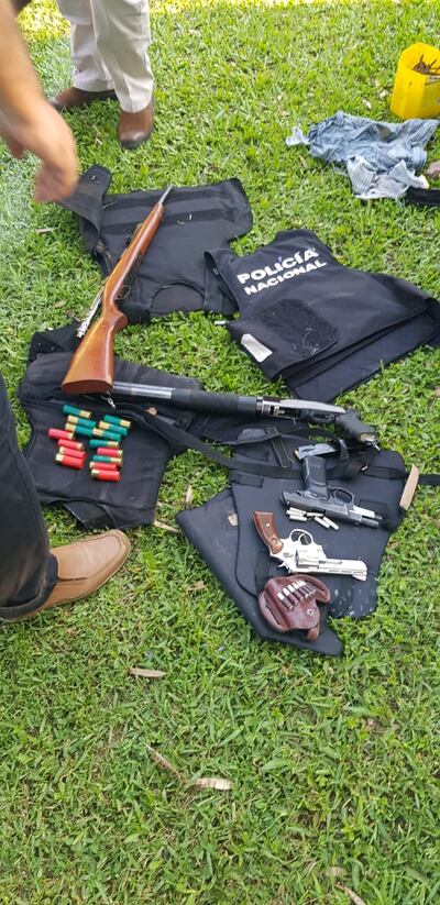 Rifles, escopetas, armas cortas y chalecos de policía fueron incautados en el vehículo.