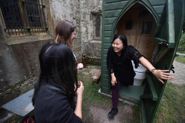 La estudiante Kae Ono (derecha) y sus amigas Andrea Stewart (L) Lingbo Zhou inspeccionan el baño de la igleisa de Santa María.