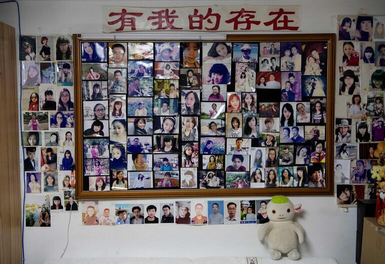 Esta foto tomada el 17 de diciembre de 2019 muestra las paredes de la casa del casamentero Zhu Fang cubiertas con las imágenes de mujeres solteras que han acudido a él a lo largo de los años en Beijing.