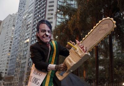 Un hombre con disfraz de Jair Bolsonaro y una sierra de papel, en la celebración del Día de la Amazonía en Río de Janeiro.