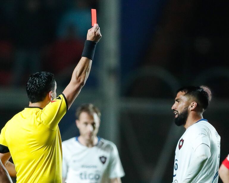 El árbitro Roberto Tobar le muestra la tarjeta roja a Alberto Espínola tras una entrada fuerte  a un rival en  mediacancha.