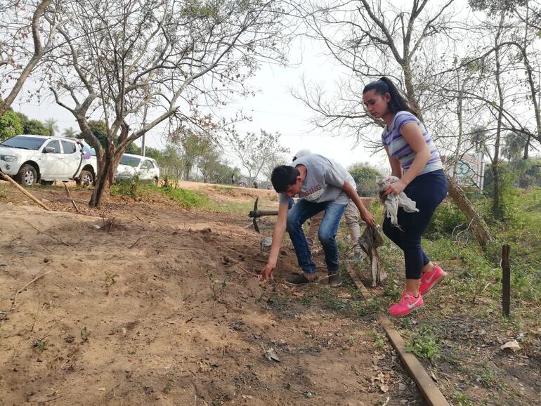 Jóvenes limpian las vías del tren en Pirayú.