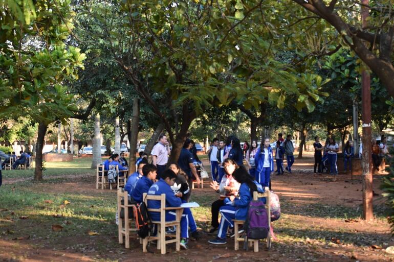 Los estudiantes dan clases en un espacio público frente a la  institución educativa.