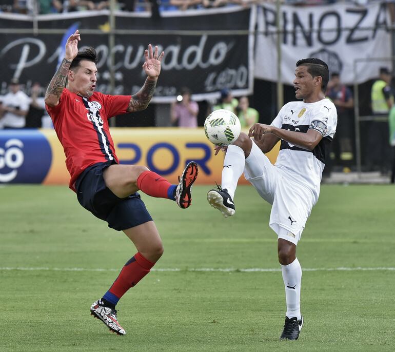 Salustiano Candia jugando un clásico con Olimpia, disputando el balón con Fabbro.
