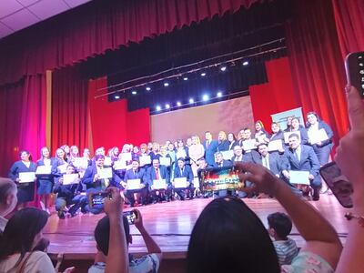 Los egresados posando con sus diplomas.