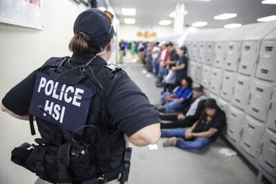 Una policía custodia a inmigrantes detenidos en Mississippi.