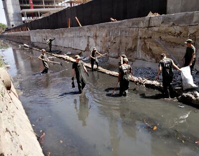 Equipados con trajes especiales, reservistas limpian un sector del arroyo Jaén, en la zona del Puerto de Asunción.