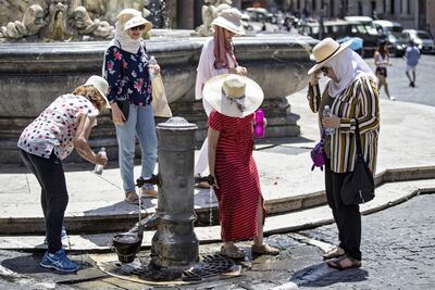 Varias mujeres se refrescan en una fuente, este viernes en Roma (Italia). La ola de calor que afecta a Europa llevó los termómetros de hoy a temperaturas superiores a los 45 grados.