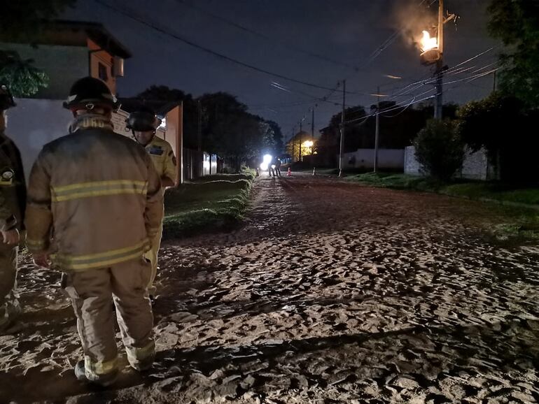 Bomberos de Mariano Roque Alonso observan sin poder hacer mucho a que un transformador de la ANDE termine de consumirse.