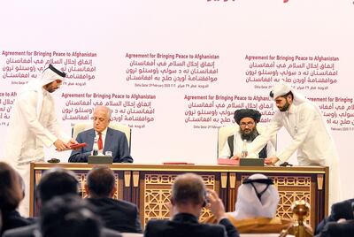 Zalmay Khalilzad (2° izq.), representante estadounidense para la paz en Afganistán, y el líder talibán,  Abdul Ghani Baradar (2° der.), durante la firma del acuerdo.