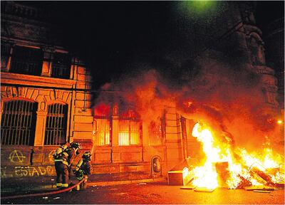 Los manifestantes hicieron fogata frente a la sede de El Mercurio en Valparaíso y luego violentaron e incendiaron el local.