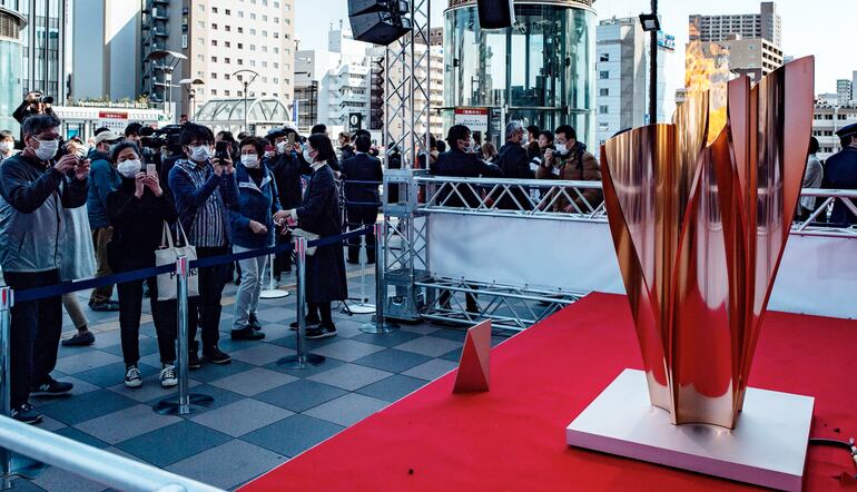 Desde la llegada a Japón de la llama olímpica, centenares de personas (con tapa bocas) se agolpan en la estación de tren de Sendai, prefectura de Miyagi (AFP).