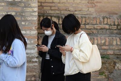 Dos mujeres utilizan sus teléfonos celulares.
