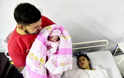 Antonhy Benítez exhibe orgulloso a su hija Alessa, quien se adelantó a su fecha y llegó a las 00:00 de ayer, junto con el Año Nuevo. La madre, quien observa la escena, espera salir de alta mañana.