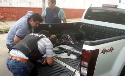 Personal de Investigaciones de Asunción verifica el arma que un vicesargento de Infantería y una mujer intentaron comercializar por US$ 6.000  en el “mercado negro”. Fue en el barrio Tacumbú.