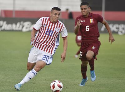 El albirrojo Braian Ojeda se escapa con el balón dominado de venezolano Miguel Navarro, en el amistoso de anoche en Tuyucuá.
