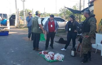 Agentes intervinientes del operativo retorno del Transchaco Rally. Se observa, en el piso, las partes faenadas de los animales silvestres incautados.