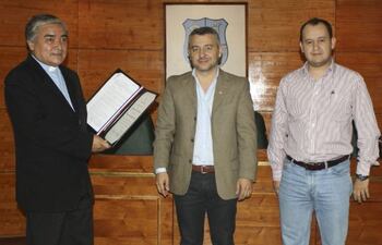 el-padre-ramon-mongelos-muestra-la-distincion-recibida-de-manos-de-los-concejales-daniel-centurion-y-felix-ayala--200350000000-626572.jpg