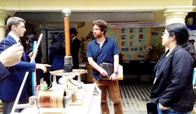 Estudiantes explican al Jurado cómo hicieron para captar la energía atmosférica y usarla para encender un fluorescente.