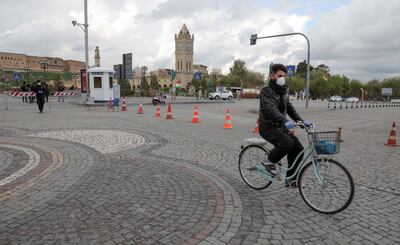 Un hombre con tapabocas se desplaza en bicicleta en la citadela de Arbil, en la regióm kurda autónoma de Irak.