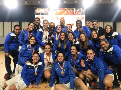 El profe Navarro junto al grupo de jugadoras y al trofeo de campeón.