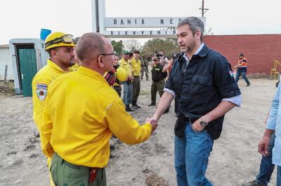 El presidente de la República, Mario Abdo Benítez (d), saluda a bomberos a su llegada a Bahía Negra en la mañana de ayer.