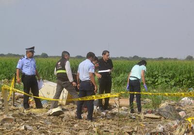 Agentes de la Policía Nacional y funcionarios del Ministerio Público observan el cadáver hallado cerca de la Costanera.