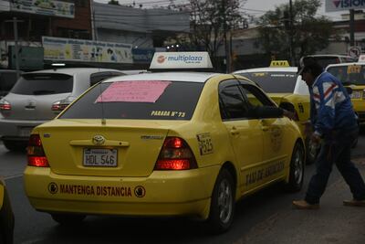 "Mantenga distancia"... uno de los taxis que se suma al bloqueo porta una cartulina criticando a la prensa por la cobertura que da al conflicto actual.