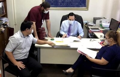 El juez de la niñez y la adolescencia, Guillermo Trovato, examina un expediente con sus funcionarios, en uno de los casos urgentes tramitados durante la emergencia sanitaria.