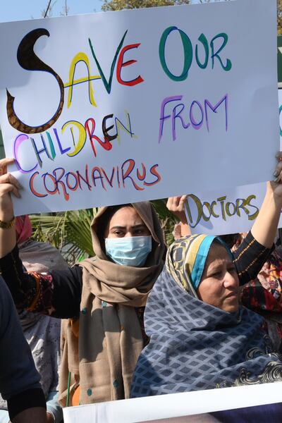Padres y familiares de estudiantes pakistaníes que estudian en la ciudad china de Wuhan, donde comenzó el brote del coronavirus COVID-19, sostienen pancartas durante una protesta para exigir al gobierno la evacuación de sus seres queridos, el pasdo el 13 de febrero de 2020.