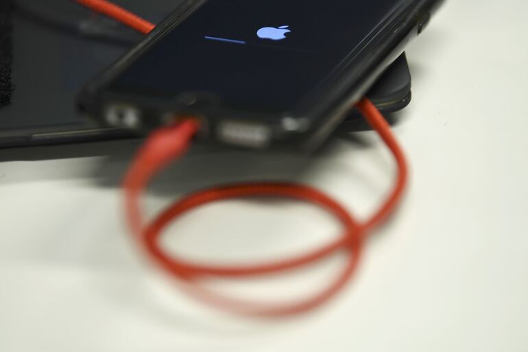 Un iPhone 6S enchufado a un cargador de batería.