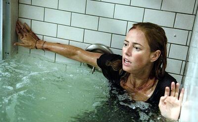 Kaya Scodelario atrapada en un baño que se inunda, con un caimán afuera, en una escena de “Infierno en la tormenta”.