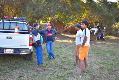 El intendente Aricio Román (con gorra roja) y el concejal Héctor Morel (recostado por la patrullera) y simpatizantes del intendente, luego del conflicto.