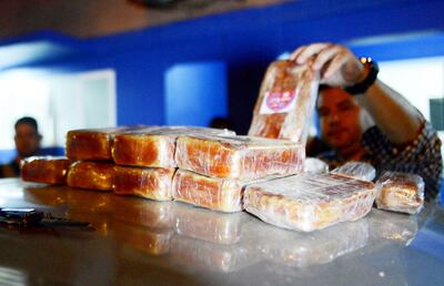 Un oficial del departamento Interpol de la Policía acomoda los panes de pasta base de cocaína hallados en un doble fondo del automóvil interceptado en el departamento de Caaguazú.