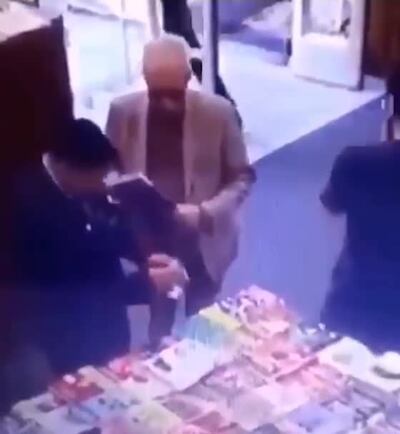 Momento en que un guardia de la librería procede a verificar los objetos que llevaba el embajador. Pagó por otros productos, pero no por un libro.